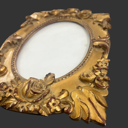 Decorative gold frame with floral designs on a black background