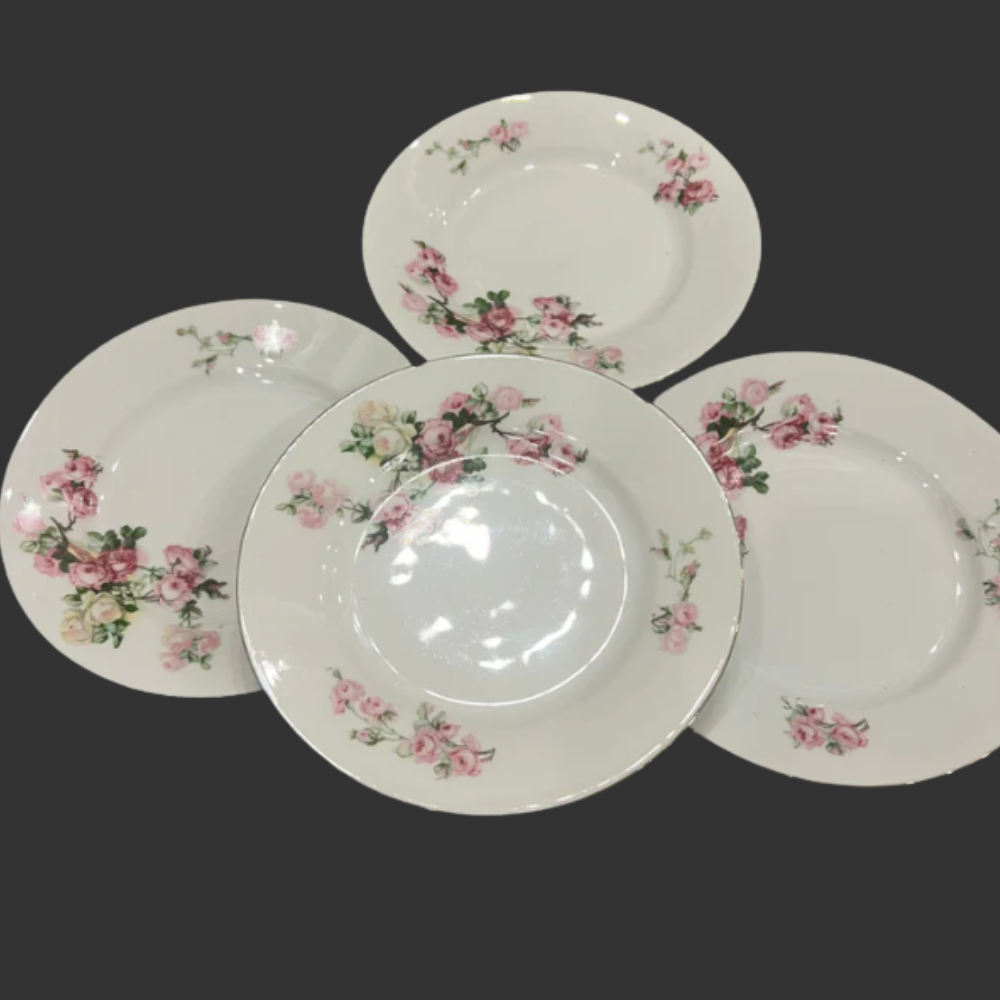 Set of four ceramic plates with floral designs on a dark background