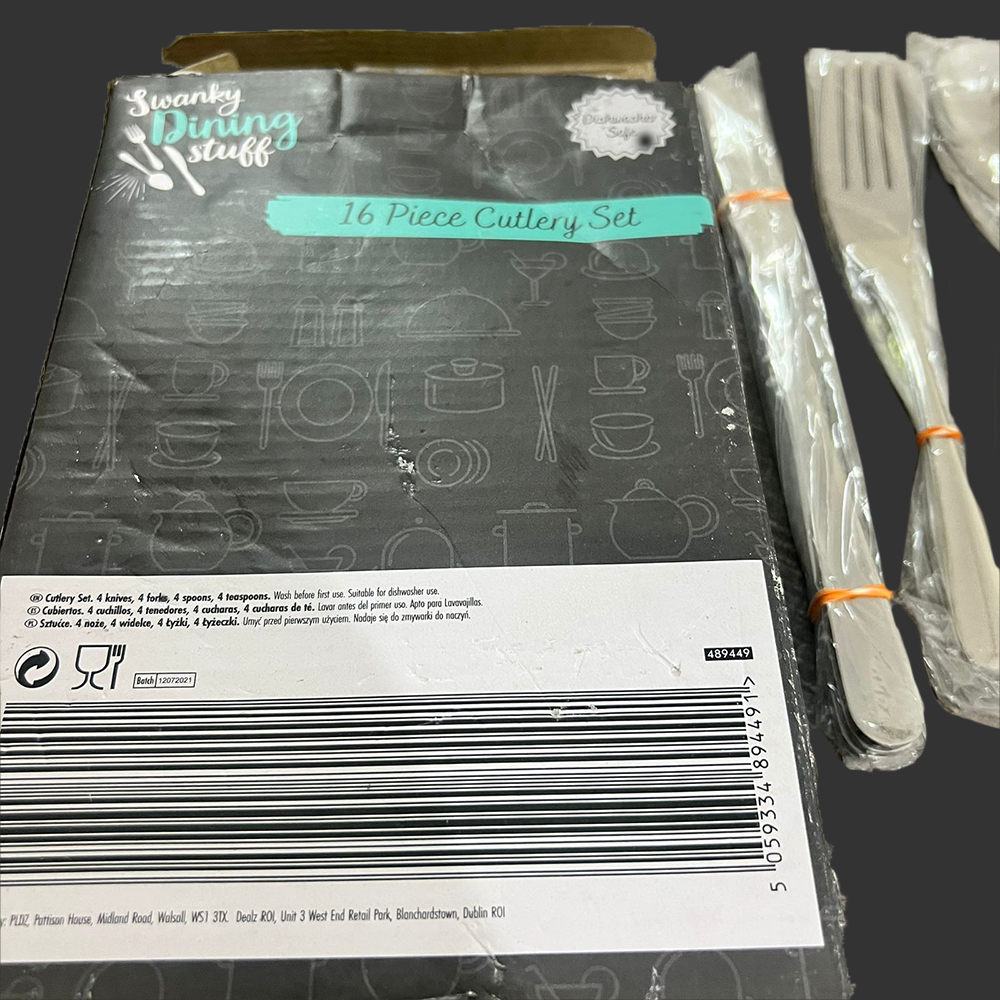 16 piece cutlery set with packaging and utensils on a black background