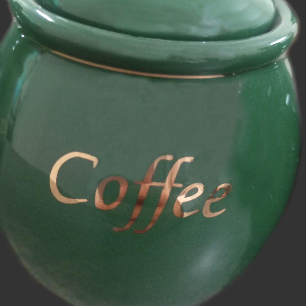 Green coffee jar with 'Coffee' inscription on a dark background