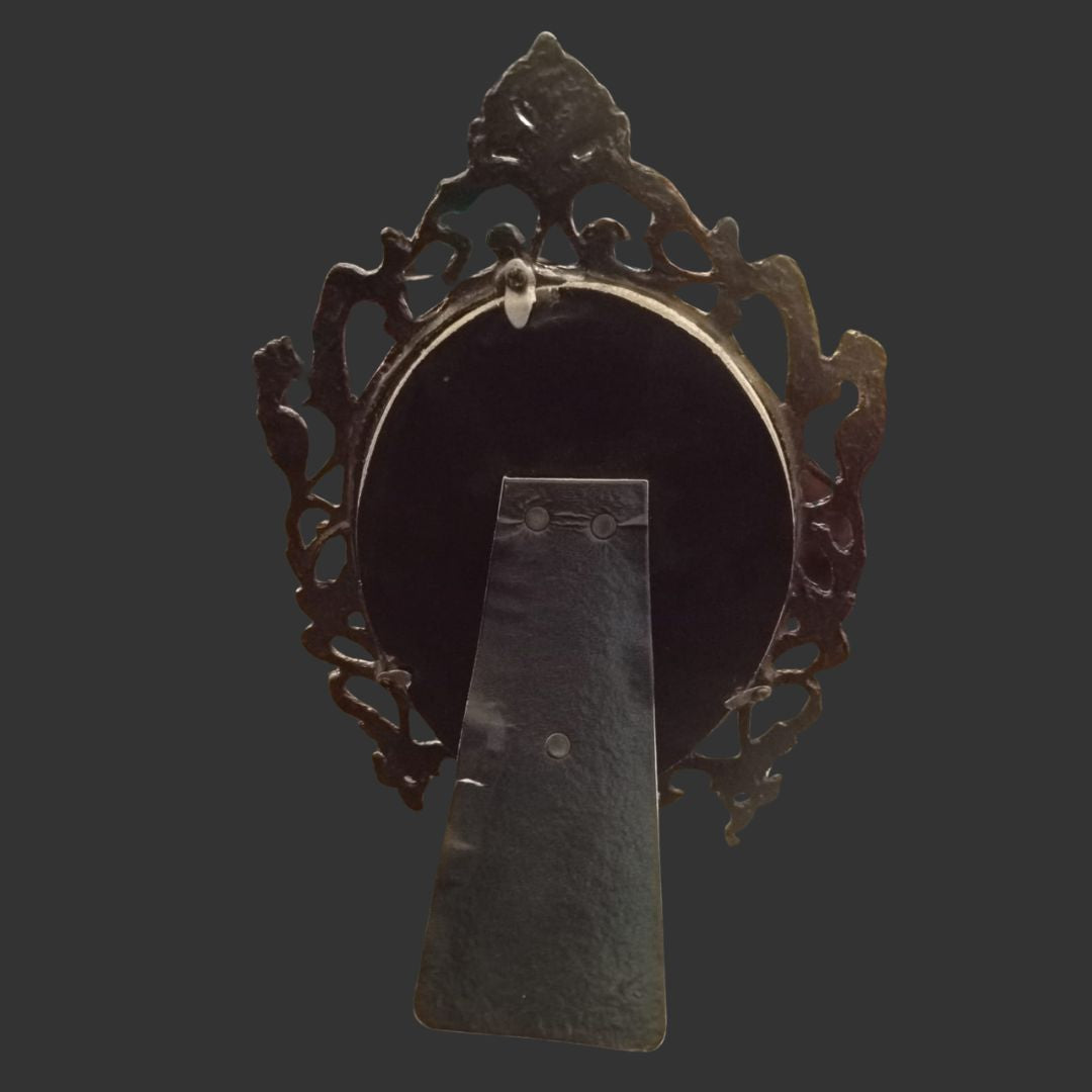 Decorative metal object with intricate design on a dark background